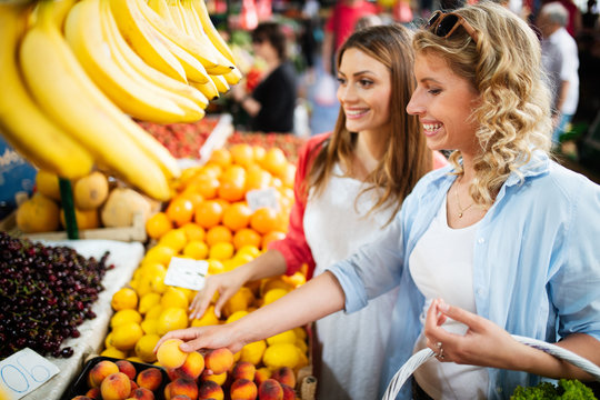 Young women shopping on the market healthy vegetables and fruits