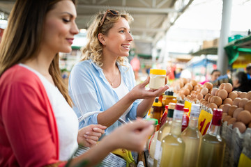 Woman buying fruits and vegetables at local food market.