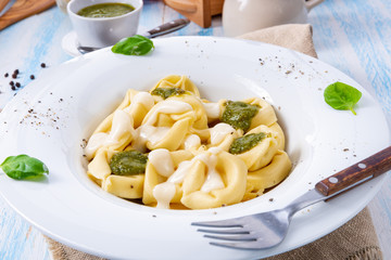 Tortellini di formaggio with basil pesto and cheese sauce