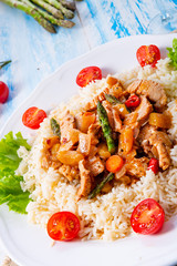 Turkey fricassee on rice with asparagus and paprika