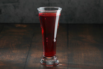 Red juicy drink in a high beer glass