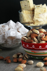 A mug of coffee and different oriental sweets: turkish delight, halva, almond and pistachio