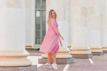 Plus size model in cotton dress at street. Girl at warm summer days , concept of fashion for ladies