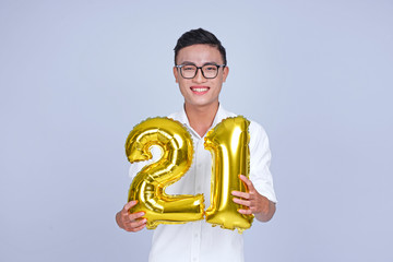 Asian young handsome attractive male student holding metallic foil balloon with number