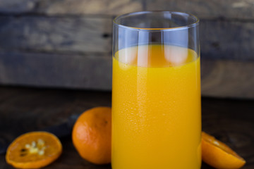 Fresh healthy orange juice, smoothie in a glass on wooden background. summer concept.