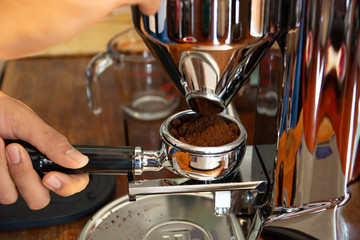 Employees are grinding coffee beans with machines to serve customers.