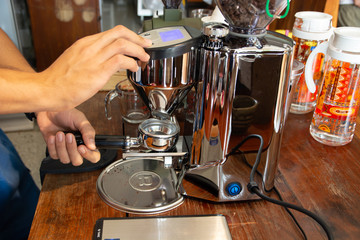 Employees are grinding coffee beans with the machine.