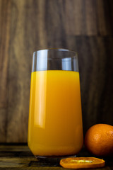 still life photo of orange juice, orange smoothie in glass on wooden background.