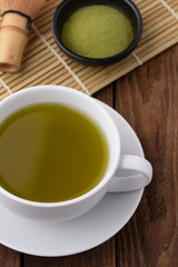 Fototapeta na wymiar hot green tea in cup on wood