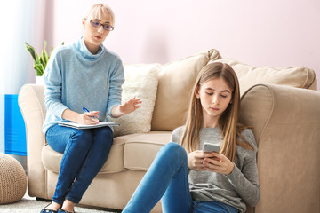 Teenage girl with mobile phone at psychologist's office