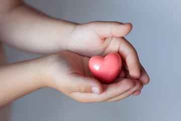 child hands holding heart, health insurance, charity concert donations. Health care, love and family concept, world heart day