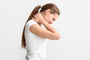 Young woman suffering from neck pain on white background