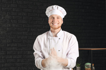 Male chef clapping hands with flour in kitchen
