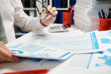 Businessman working and calculating, reads and writes reports. Office employee, table closeup. Business financial accounting concept.