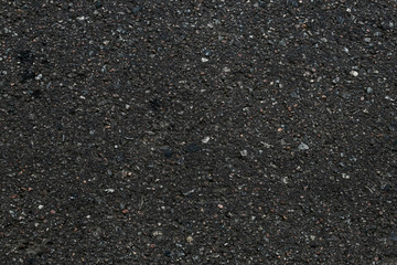 Asphalt textured background. Dark asphalt surface texture. Abstract close-up of black backdrop. Pattern of stone, gravel background. Copy space of grunge wall. Old road, roadway, bitumen street floor.