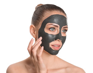 Beautiful young woman with facial mask on white background