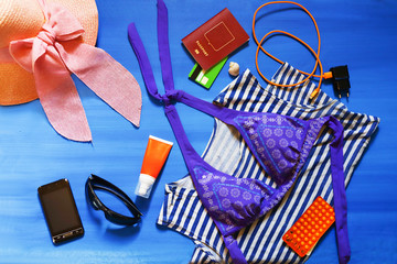 colorful summer female fashion outfit flat-lay. Top view. Summer fashion, holiday, striped shirt, swimsuit, camera, medications.