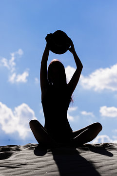 woman practicing yoga on beach at sunset