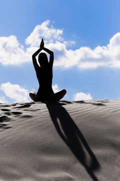 Yoga on a sandy hill.