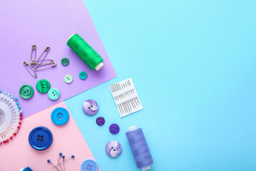 Set of sewing threads and accessories on color background