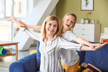 Happy woman with little adopted boy at home