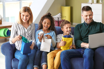 Happy couple with little adopted children after shopping at home
