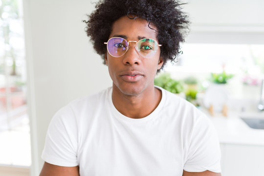 African American man wearing glasses Relaxed with serious expression on face. Simple and natural with crossed arms