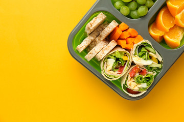 School lunch box with tasty food on color background