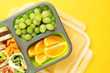 School lunch box with tasty food on color background