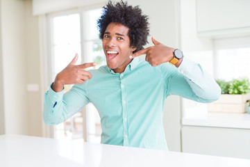 African American business man wearing elegant shirt smiling confident showing and pointing with fingers teeth and mouth. Health concept.