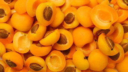 Ripe juicy orange apricots slices fruit background.