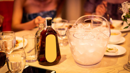 Ice buckets and decanters on the table with a full plate and glass