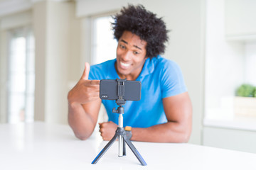African American man doing online call with webcam using smartphone very happy pointing with hand and finger
