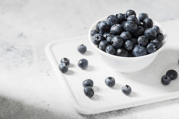 Blueberries in a white bowl on a light background