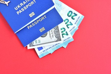 Biomedical Ukraine id passport with dollars and euro cash on red background, selective focus. Tourist trip concept with identity document and money. Documents for business trip. Ukrainian passports 