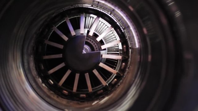 Inside a mock up of an turbine for an helicopter oder airplane. the fan is slowly spinning. close up shot
