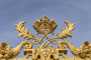 Fototapeta na wymiar The golden entrance gate of the famous Palace of Versailles. Palace Versailles was a royal chateau. Versailles, Paris, France.