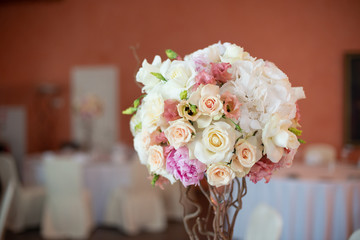 bouquet of flowers on a leg in the interior of the restaurant for the celebration of the flower shop wedding salon