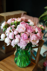 peonies in a bouquet of flowers on a leg in the interior of the restaurant for a celebration shop floristry wedding salon
