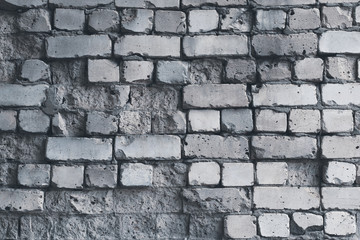 Dilapidated white brick wall, grunge background. Gray brick wall pattern, weathered texture. Grey stone concrete wall. Old cracked obsolete brick facade. Rough surface of urban dirty building.