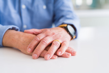 Close up of man hands with hands on each other over white table