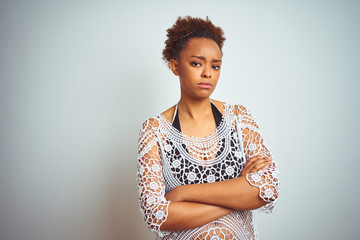 Young african american woman with afro hair wearing a bikini over white isolated background skeptic and nervous, disapproving expression on face with crossed arms. Negative person.