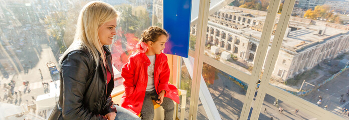 Portrait of happy mother and baby talking in big ferris wheel.Relationship concept.