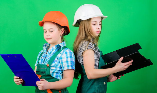 Checking every detail for defects. small girls repairing together in workshop. Foreman inspector. Repair. Labor day. 1 may. teamwork business.. Little kids in helmet with tablet