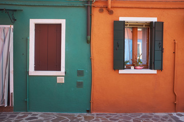 Beautiful vibrant colorful houses in Burano with narrow street near Venice in Italy.