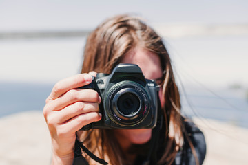 Young girl learning photography with a DSLR