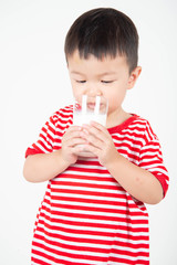 Little Asian boy drinking milk from th glass with happy face