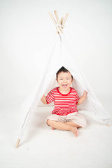 Little Asian toddler boy sit in the tent at home with happy smile © wckiw