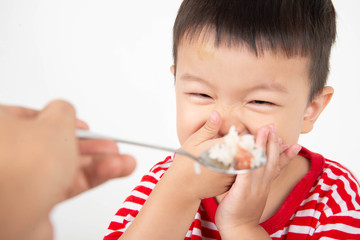 Little toddler Asian boy with hand close his mouth no eat his food