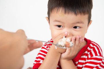 Little toddler Asian boy with hand close his mouth no eat his food